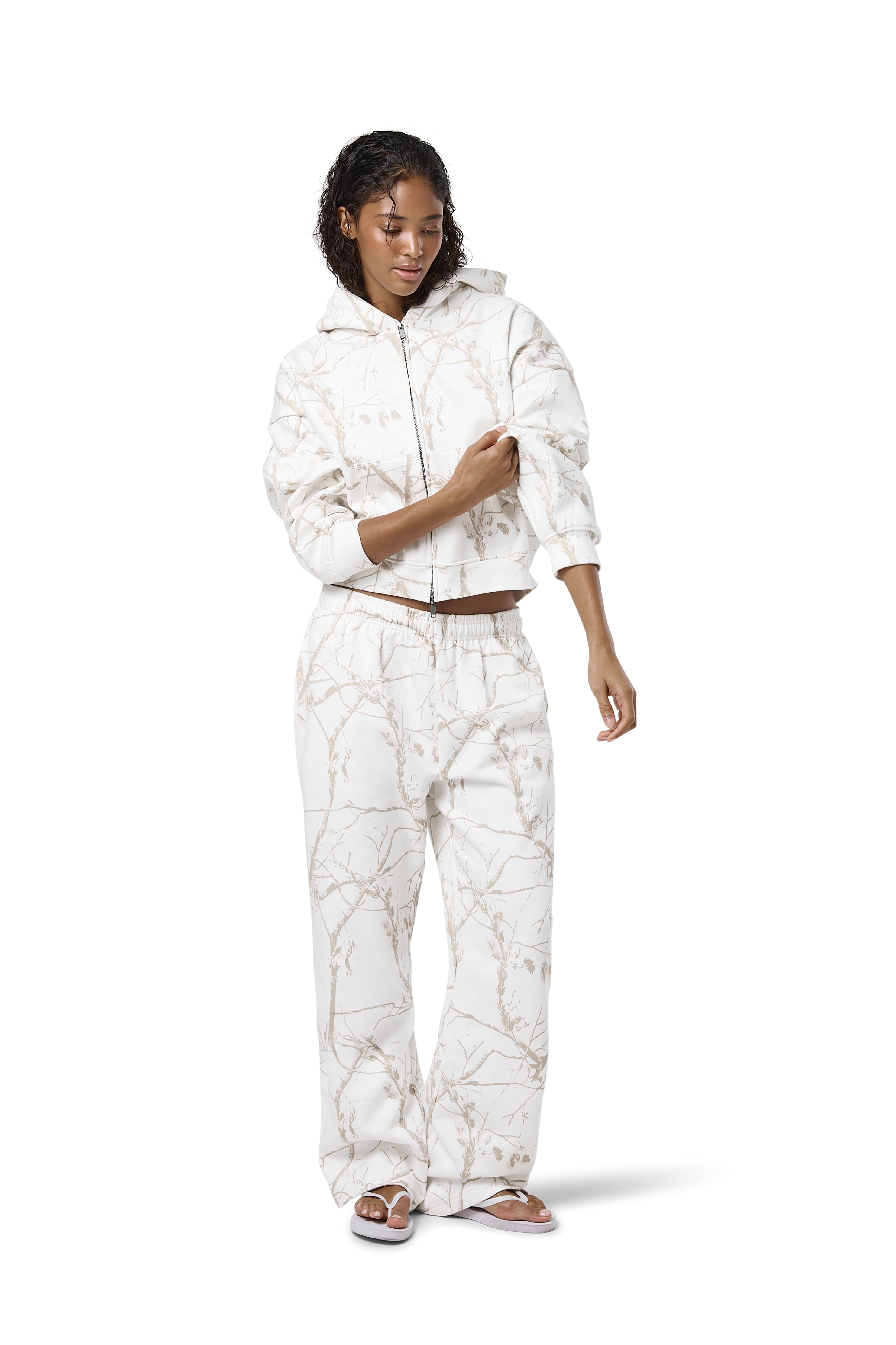 Off-white camouflage print sweatpants in a 'milk' shade, featuring a subtle twig pattern, available in petite, regular, and tall sizes.